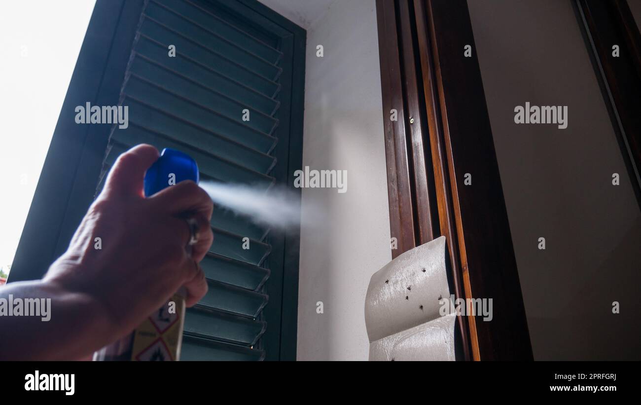 hand using mosquito insecticide spray to kill flies and mosquitoes