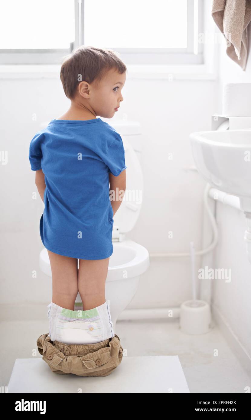 Potty training. Rearview shot of a young boy going to the bathroom