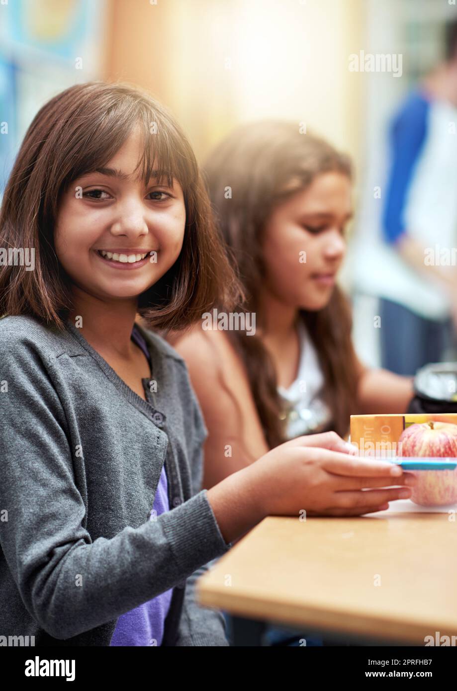 Cant to see what lunch Mom packed. Portrait of young school children eating lunch at school Stock Photo