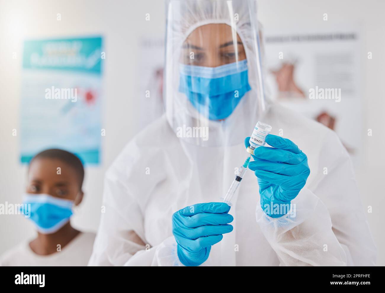 Vaccine, injection and medicine cure for covid, monkeypox and ebola with doctor, healthcare or medical professional. Frontline worker in hazmat suit getting ready to inject clinic or hospital patient Stock Photo