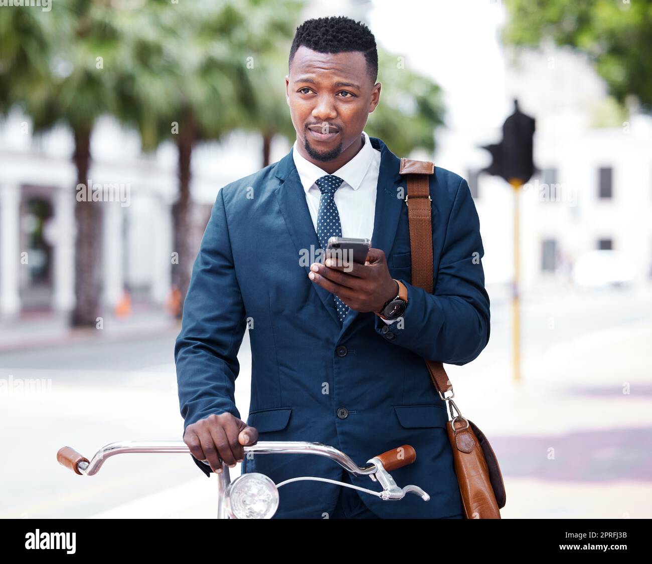 Phone, business and bike with a business man on his morning commute into work in the city. Businessman on the internet with 5g mobile technology on bicycle travel to decrease his carbon footprint Stock Photo