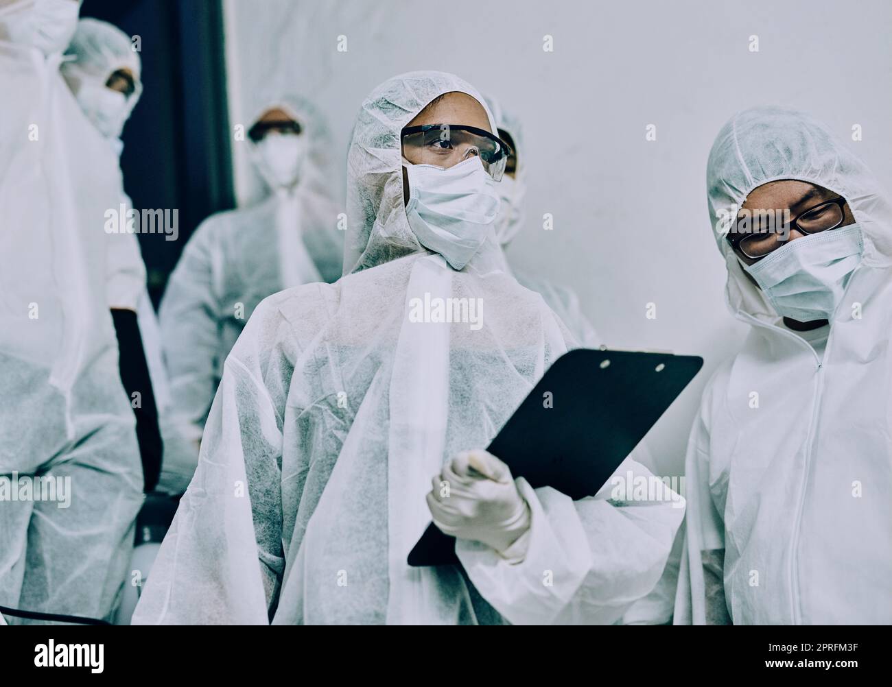 Doctors, healthcare workers and health team doing inspection, cleaning a building during covid pandemic and checking for danger. Employees wearing masks to protect from virus at a working site Stock Photo