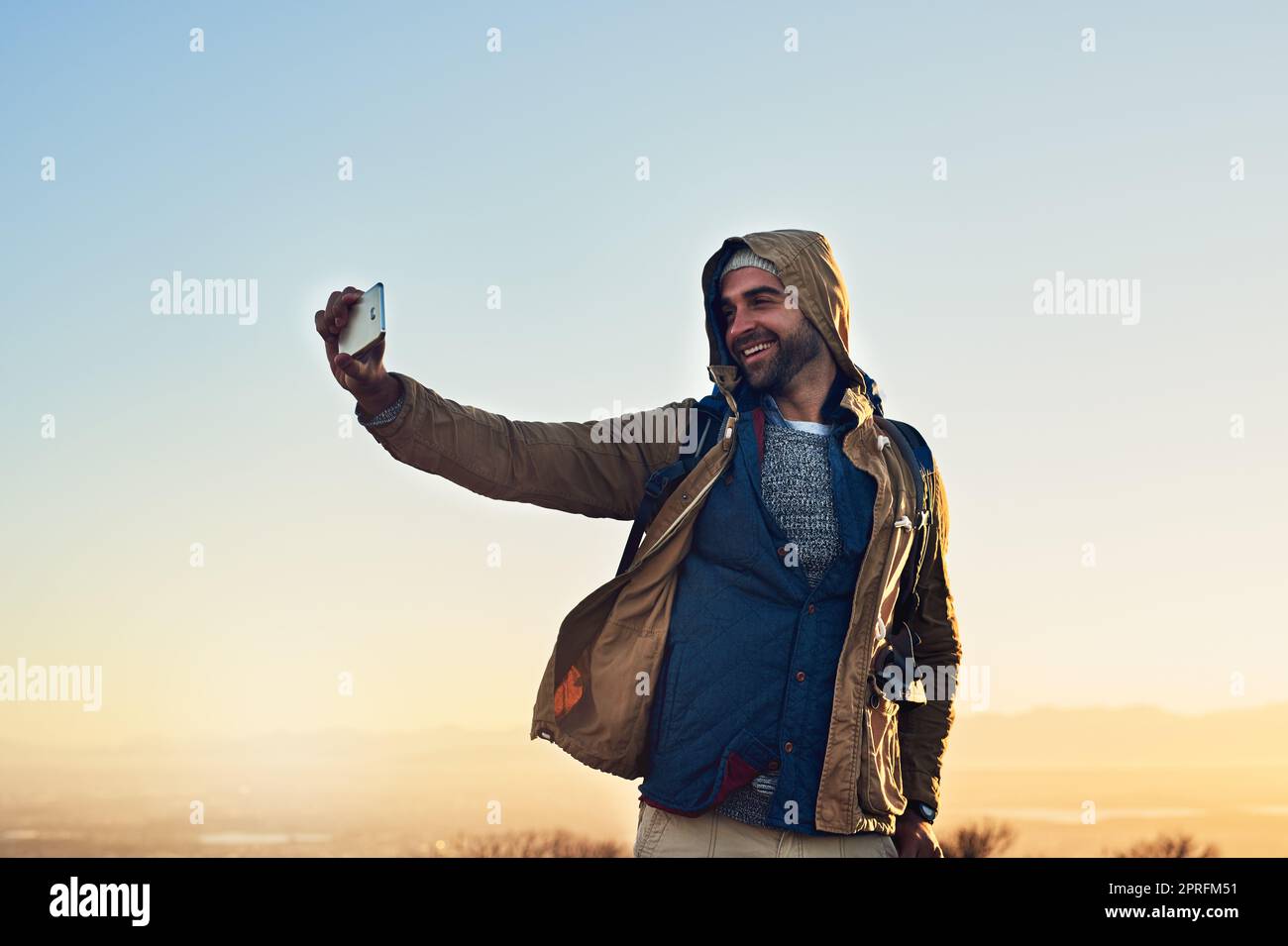 These photos will be great for my online profile. a hiker on top of a mountain taking a photo of himself. Stock Photo