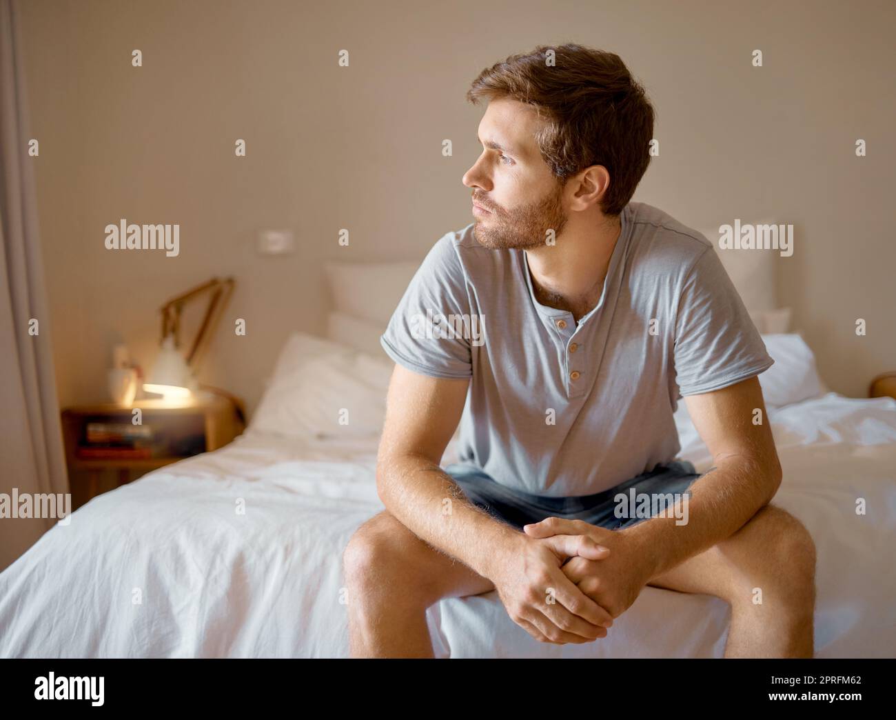 Depression, anxiety, mental health, burnout sad man, thinking and depressed insomnia night. Anxious man stressed, sitting in the bedroom thinking of memories and ideas about the future Stock Photo