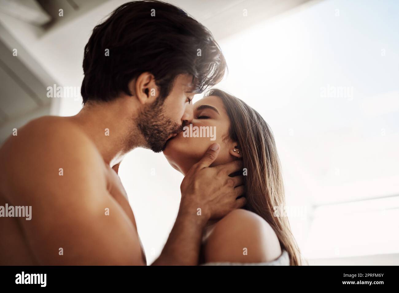 Your kisses make me weak. an affectionate young couple in their bedroom at home. Stock Photo