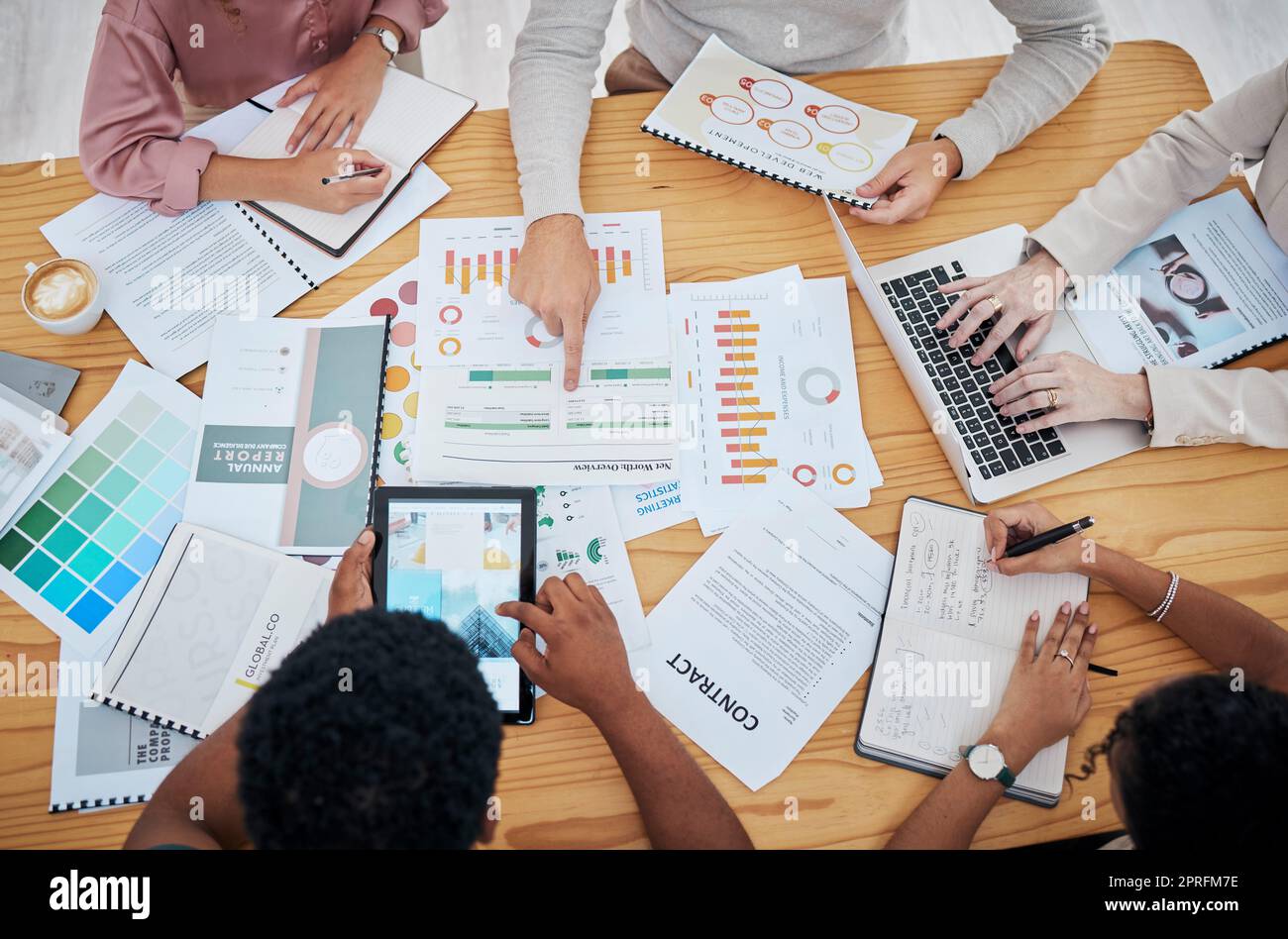 Meeting, planning and finance with a group or team of business people discussing data, a contract or financial report from above. Overhead of a boardroom meeting for strategy, growth and development Stock Photo