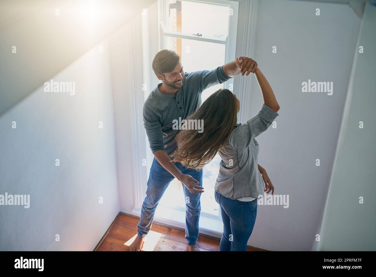 Dancing until the sun goes down. an affectionate young couple dancing at home cheerfully. Stock Photo