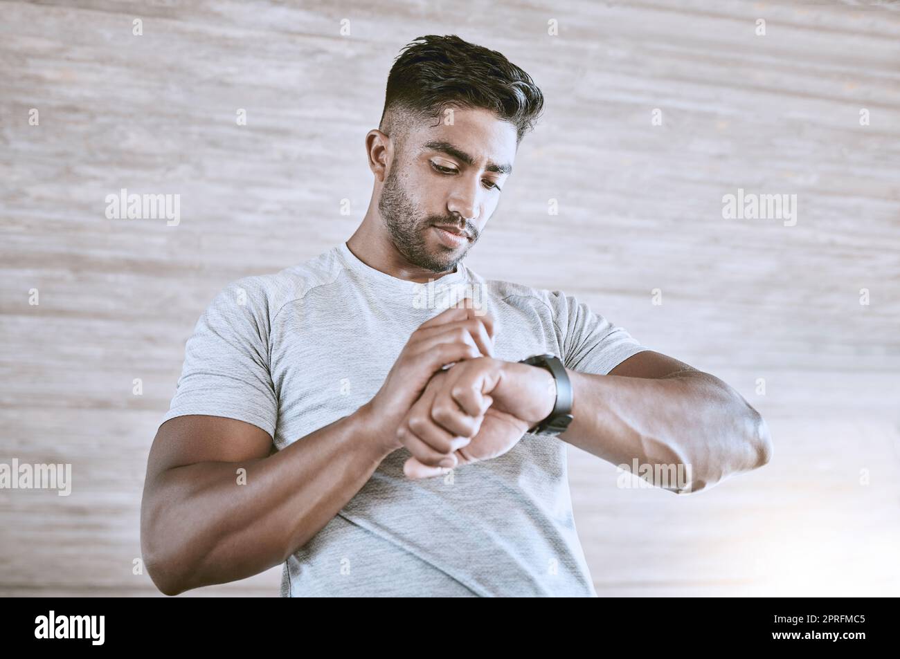 Man with digital smartwatch for health, fitness and performance progress tracking after exercise or training. Strong and healthy young man or athlete check with tracker watch for time and heart pulse Stock Photo