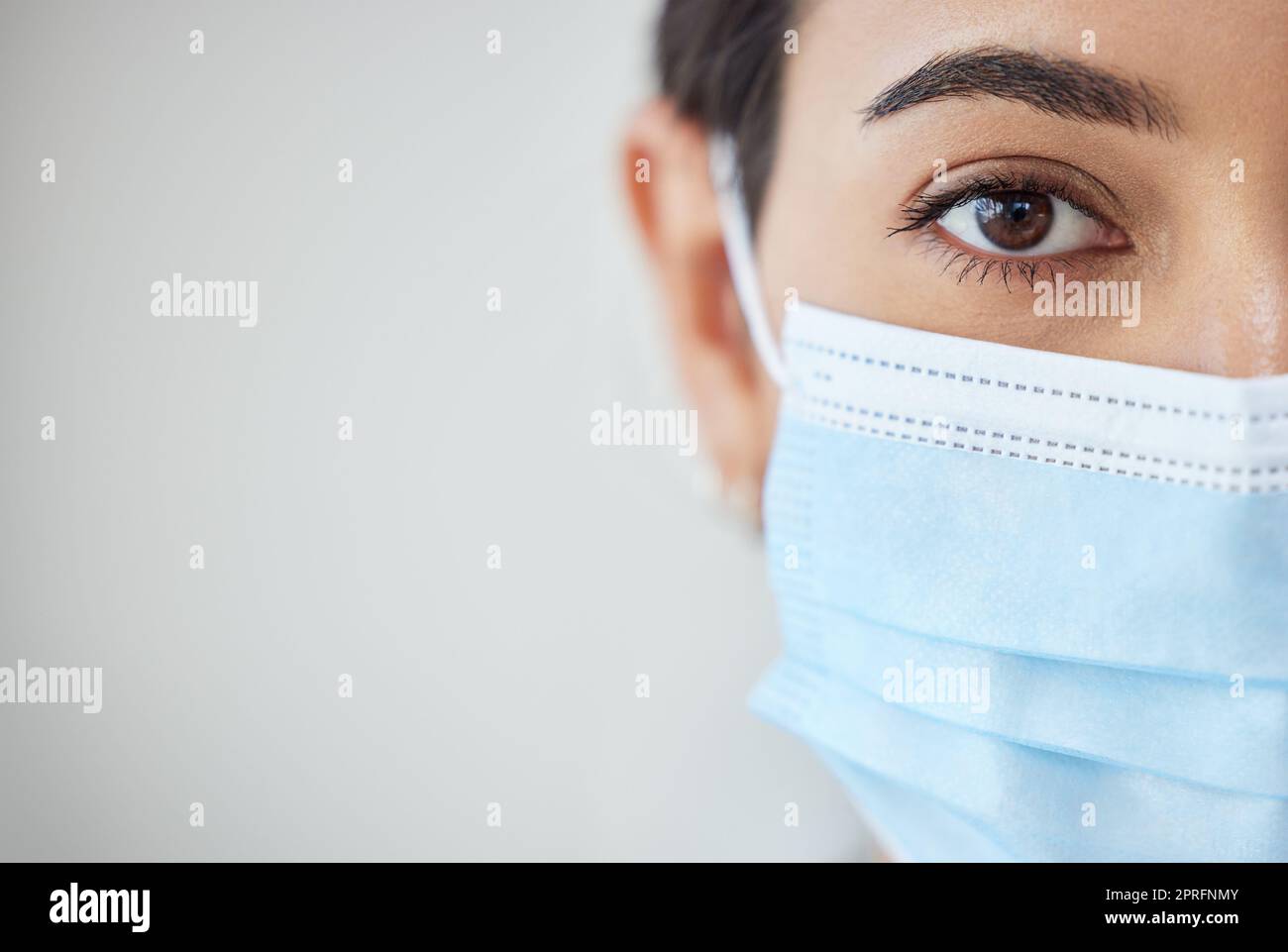 Health, wellness and covid safety mask of a young woman face and head. Eye zoom of a female with nose and mouth cover for prevention and protection from corona virus, flu and cold in a pandemic Stock Photo