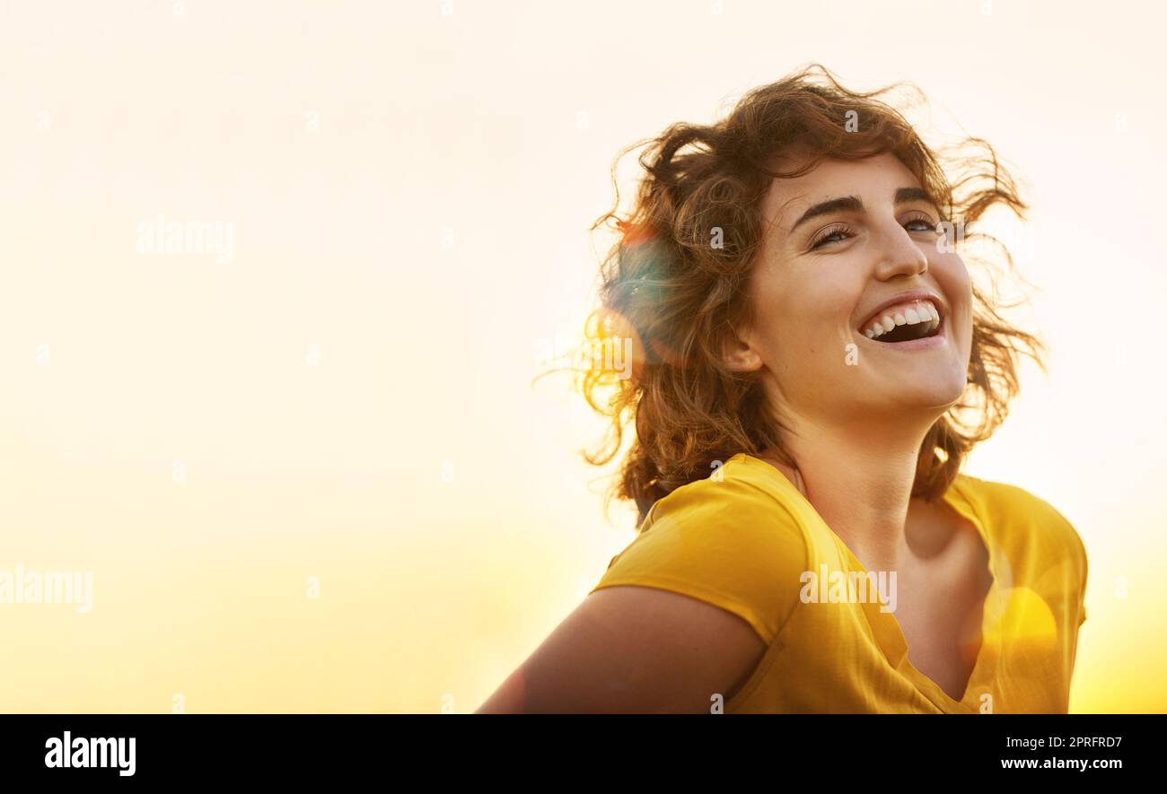 Yellow is the happiest color. a cheerful young woman laughing while