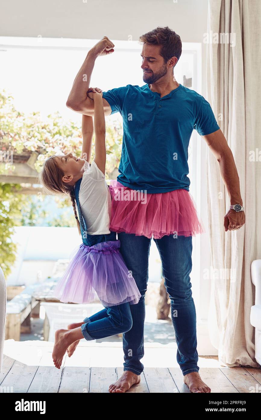 Hes a Super Dad. a little girl holding on to her fathers arm while he flexes. Stock Photo