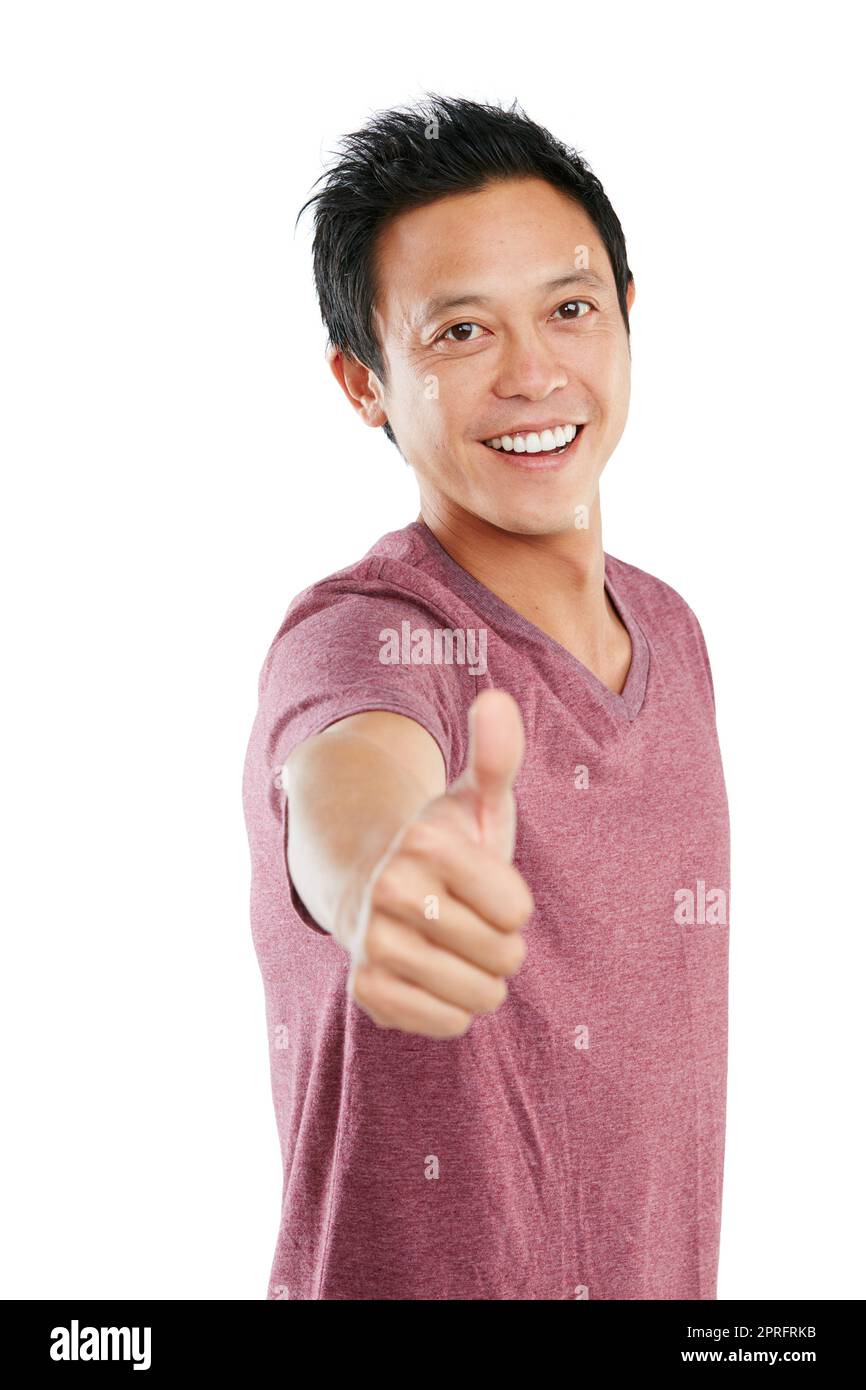 Keen to show his approval. Studio portrait of a young man standing and giving a thumbs up against a white background. Stock Photo