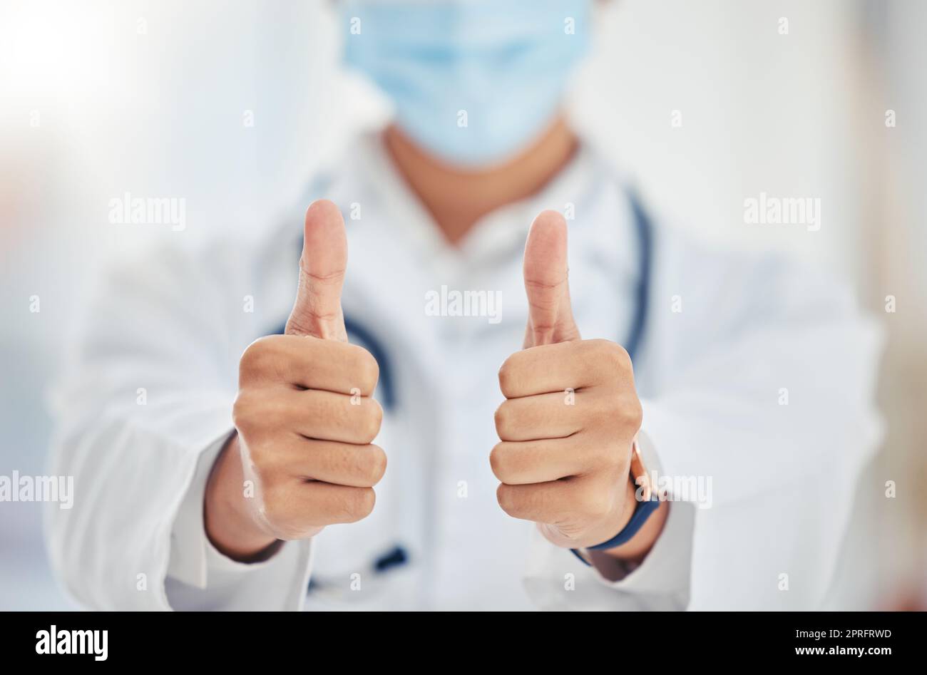 Thumbs up doctor hand sign for covid surgery success, support and yes in a hospital. Medical and healthcare worker showing thank you, agreement or goal completion hands gesture in a health clinic Stock Photo