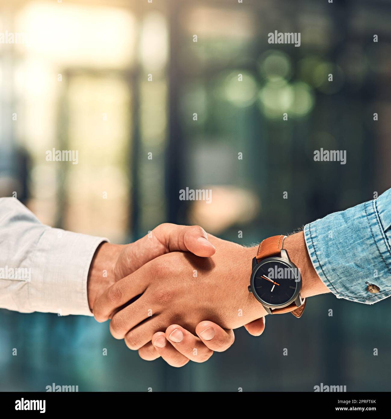 Well do great things together. two unidentifiable young business partners shaking hands in the office. Stock Photo
