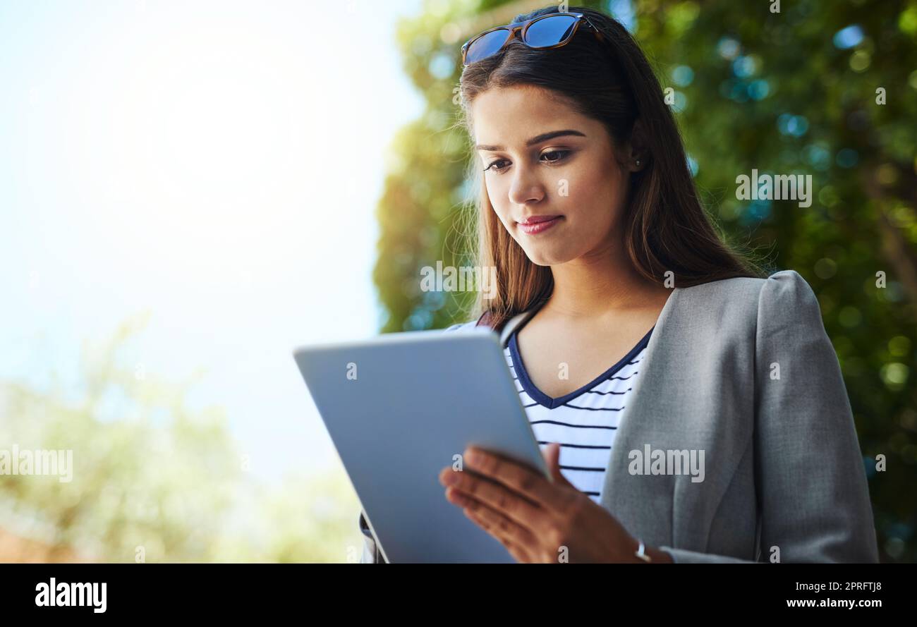 Working while commuting. an attractive young woman using her tablet while commuting to work. Stock Photo