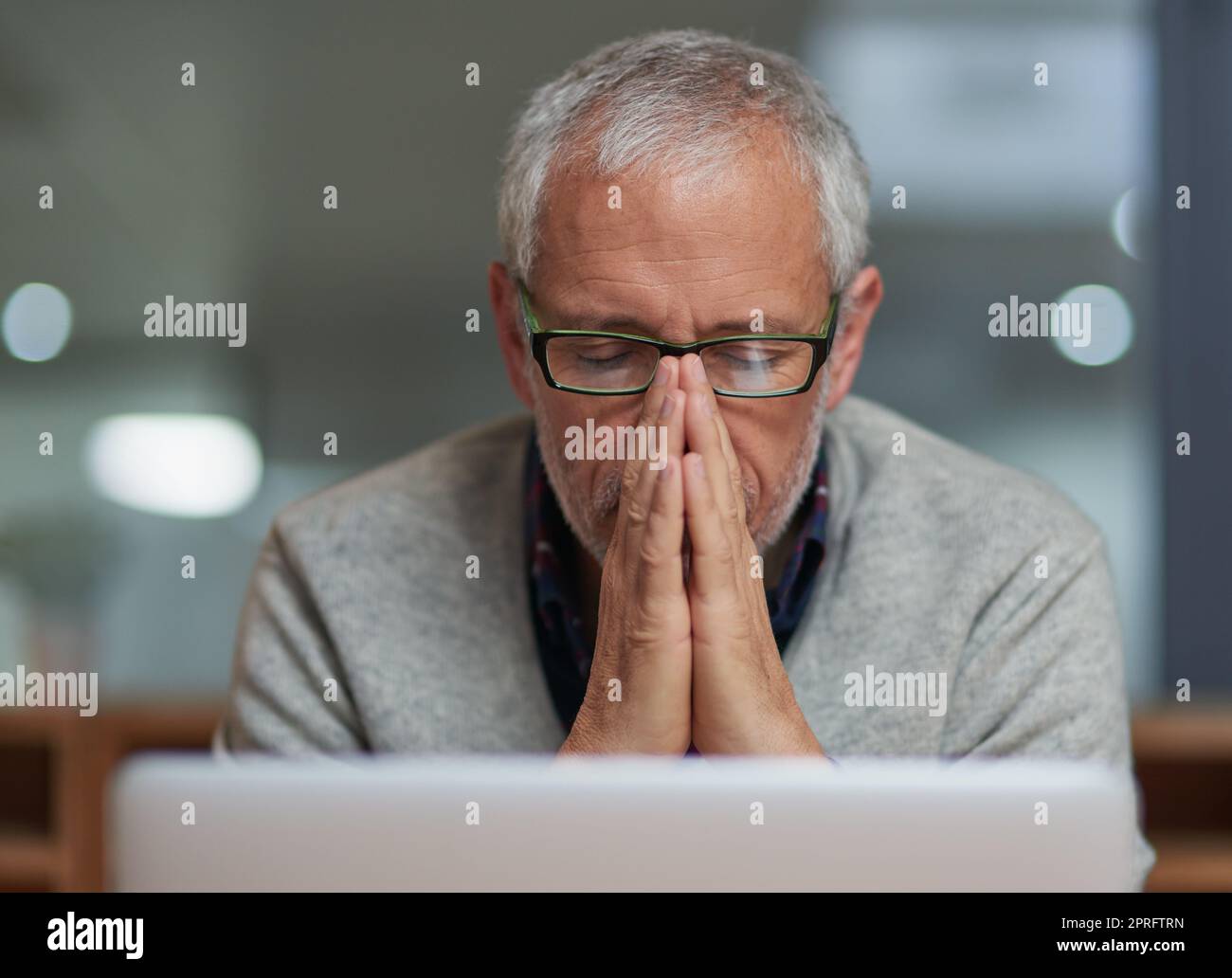 Feeling the pressure of work. a stressed out mature businessman using a laptop while working in an office. Stock Photo