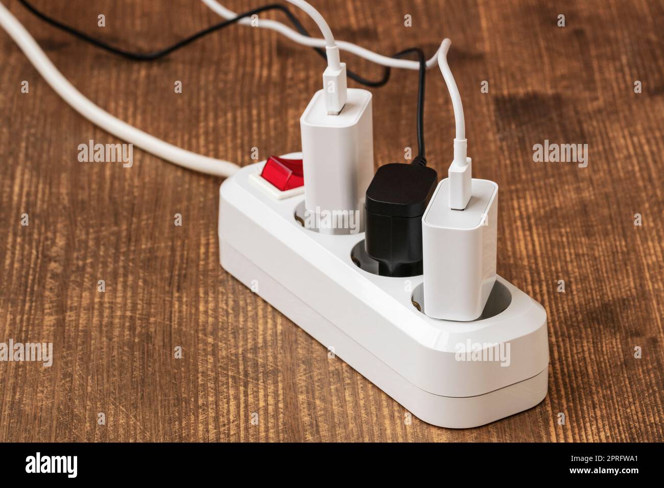 Electrical plugs with cords connected to electrical power strip Stock Photo