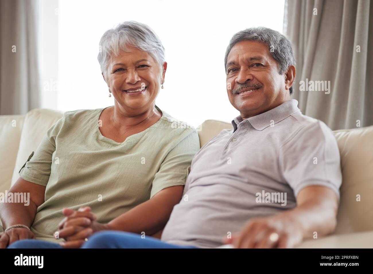 Love, smile and senior couple on living room interior sofa relax and lounge together at home portrait. Face of happy people, man and woman smile while living retirement lifestyle at family house Stock Photo