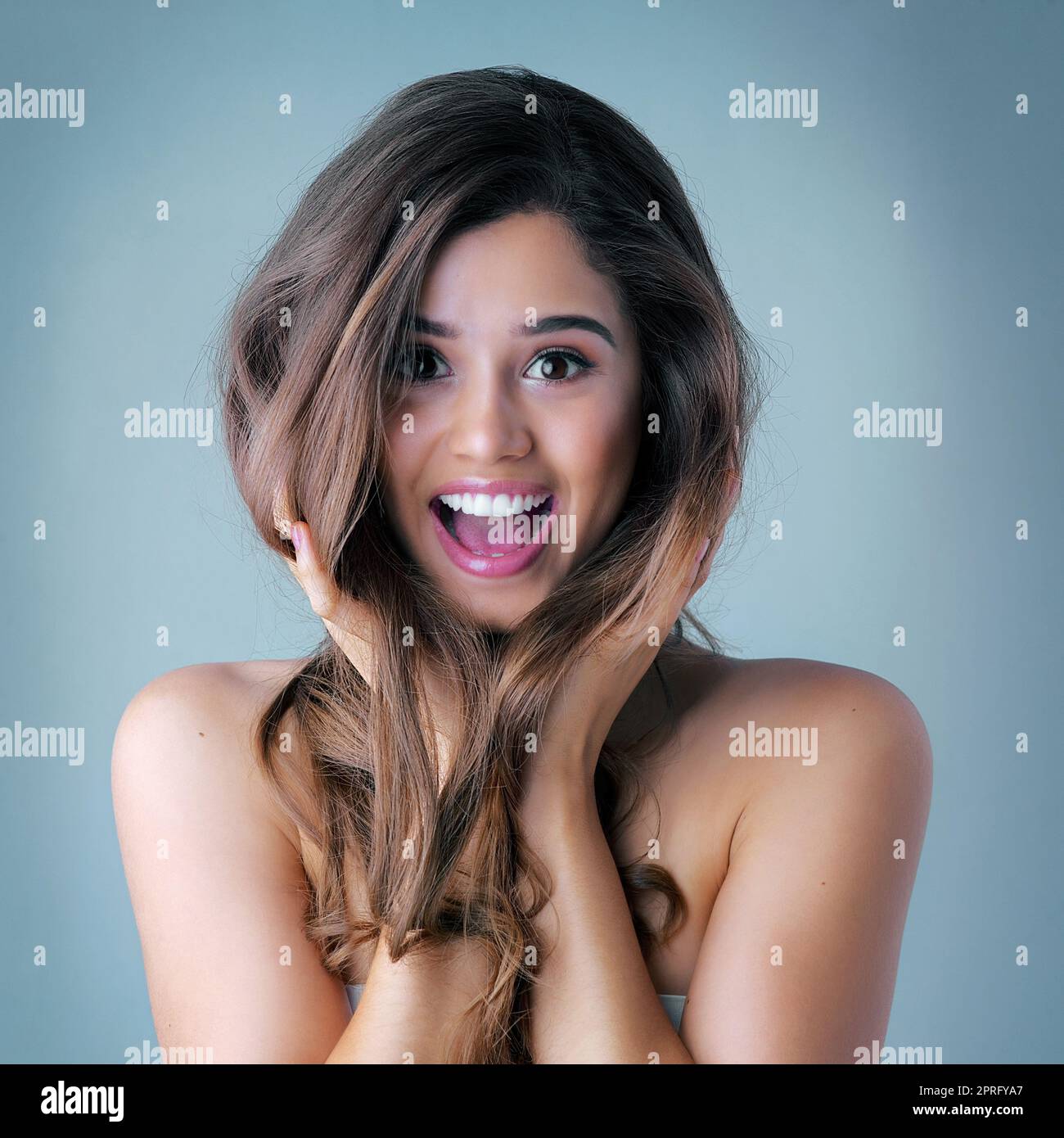 Healthy, beautiful, shiny hair starts now. Studio shot of a beautiful young woman posing against a gray background. Stock Photo