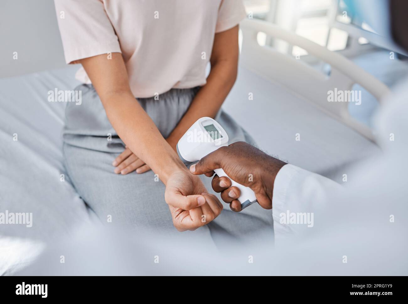 Doctor check temperature of sick covid patient to test fever, risk of disease or flu. Healthcare worker hands scanning with laser thermometer for virus safety and clinic service in medical hospital Stock Photo