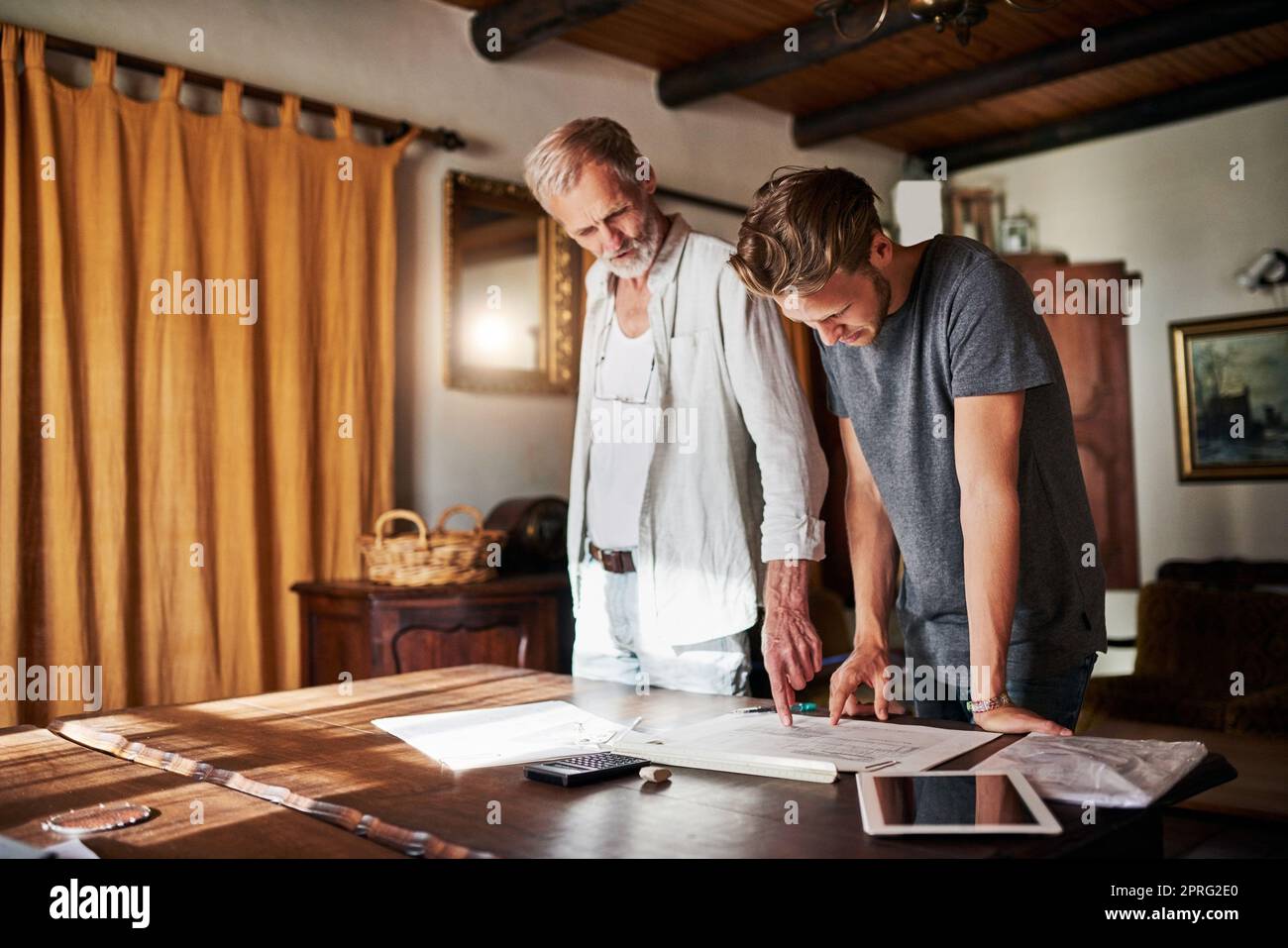 They share a passion for building dreams. two men working on a project together at home. Stock Photo