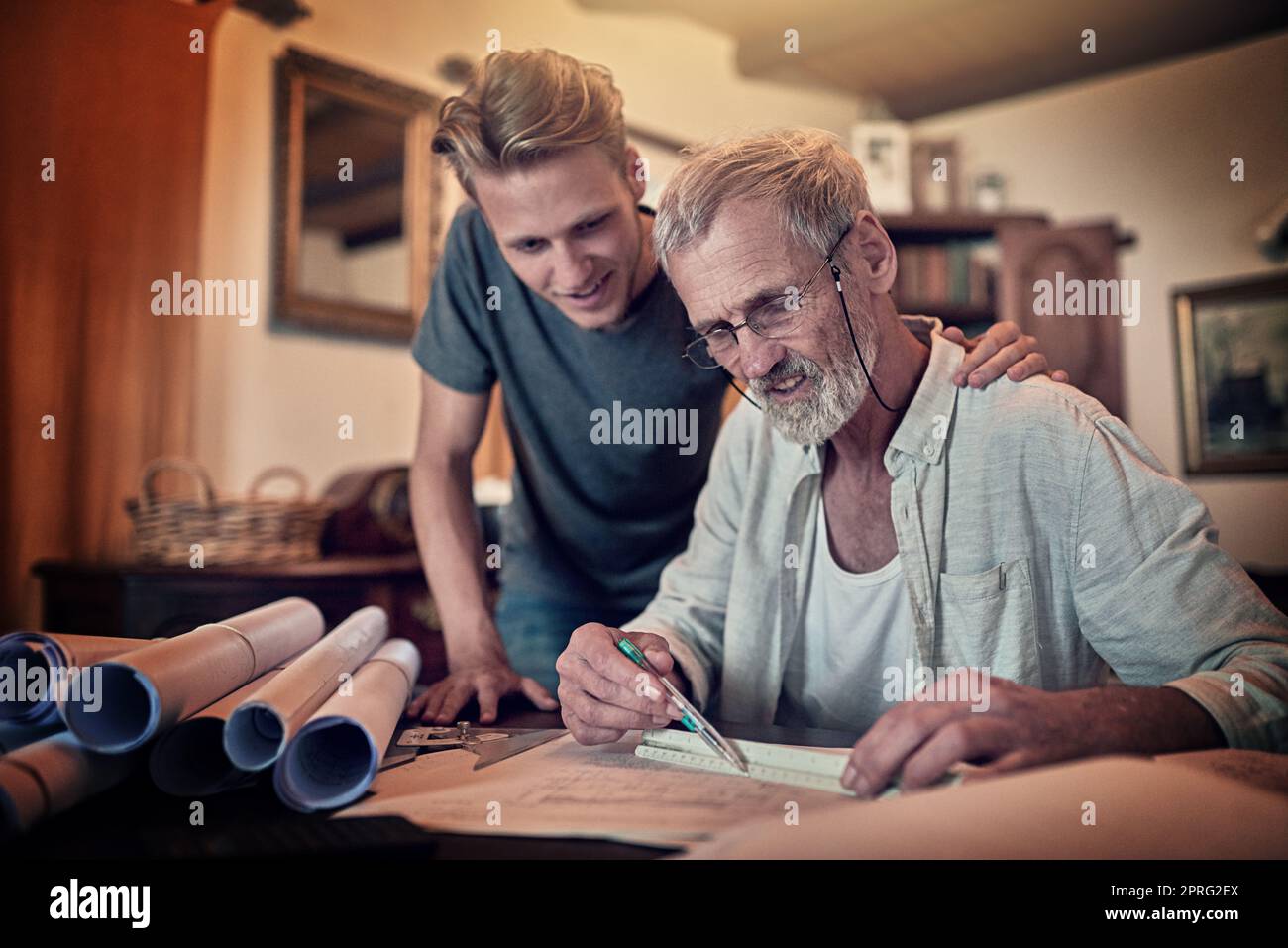 Two minds are better than one. a father and his son working on a design for their family business at home. Stock Photo