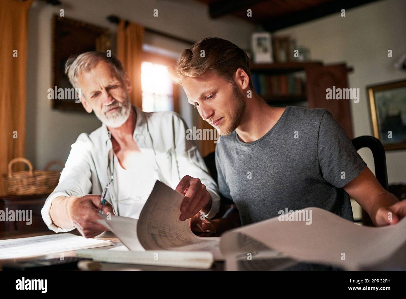 My dad is the best person to come to for help. two men working on a project together at home. Stock Photo