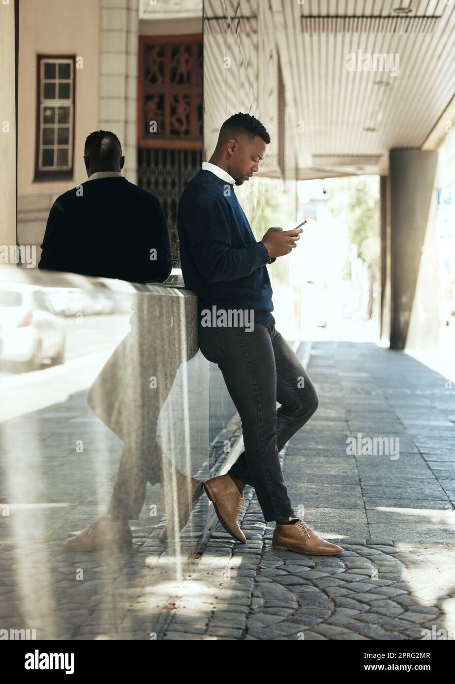 Networking, phone call and businessman in city reading email, schedule agenda or social media. Manager employee working, thinking or texting online while standing outside the office building Stock Photo