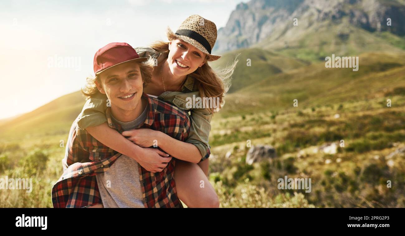 Ill carry her up any mountain to make her smile. Portrait of a happy young couple enjoying a piggyback ride in nature. Stock Photo