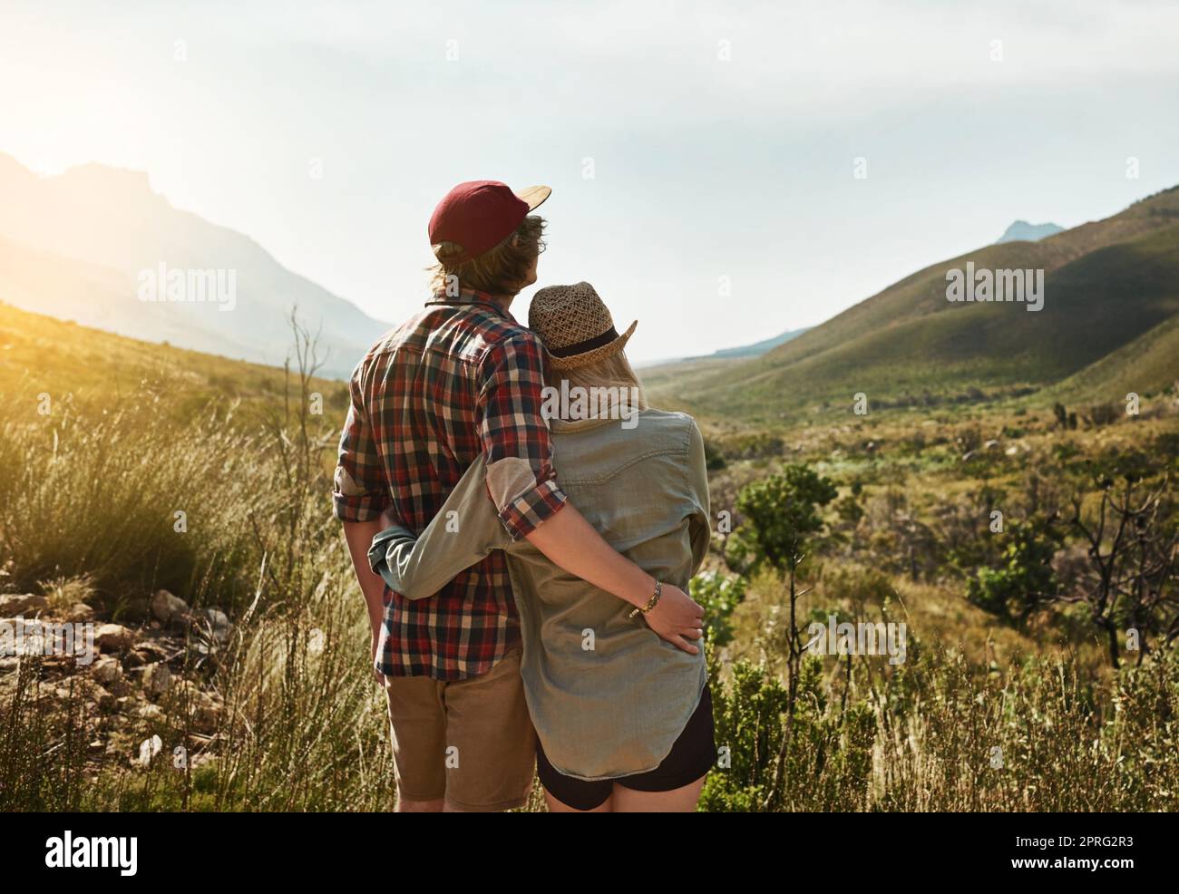 Climb a mountain to get to the good life. Rearview shot of a young couple admiring a mountainous view in nature. Stock Photo