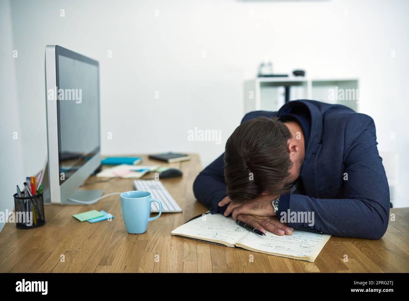 Out for the count at work. a stressed out businessman passed out at his desk. Stock Photo