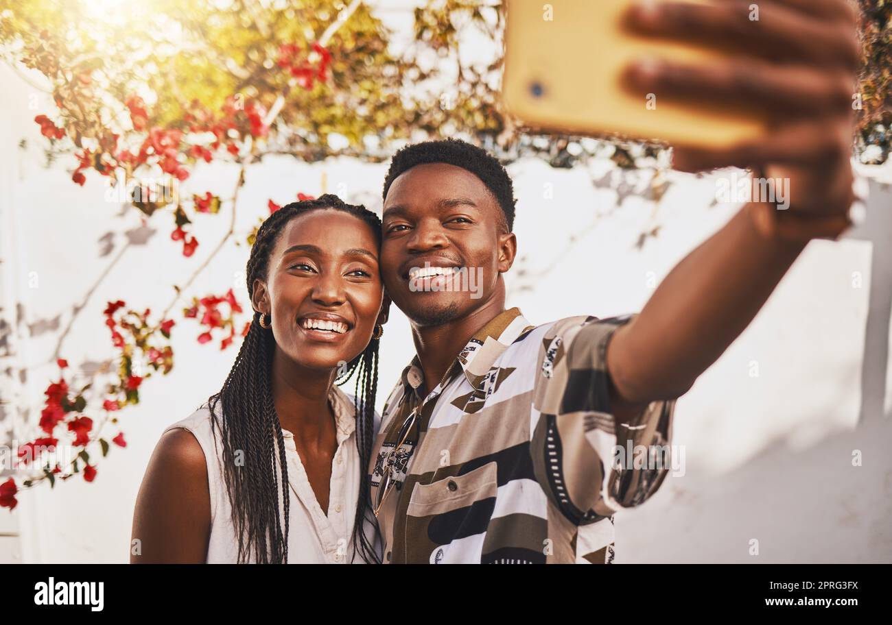 Man and woman love taking a selfie portrait together as a couple smiling during summer under relaxing sun. Happy, smile and free boyfriend and young girlfriend take pictures on phone for social media Stock Photo