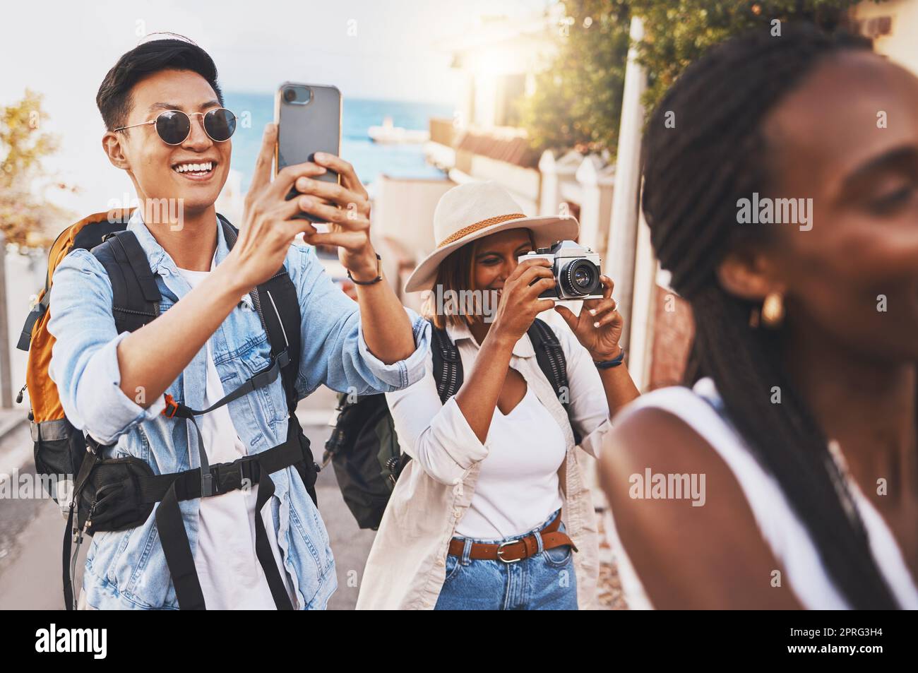 Happy photographer people on travel summer vacation or holiday for international tourism and lens flare. Young influencer or tourist man, woman and friends doing photography for social media branding Stock Photo