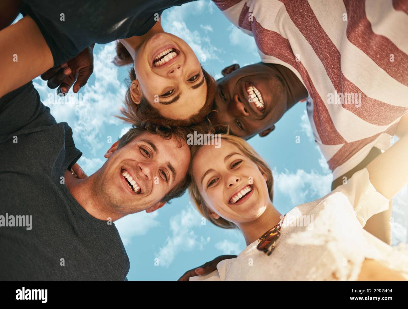 Its happy time. Low angle shot of a group of young friends huddled together in solidarity. Stock Photo
