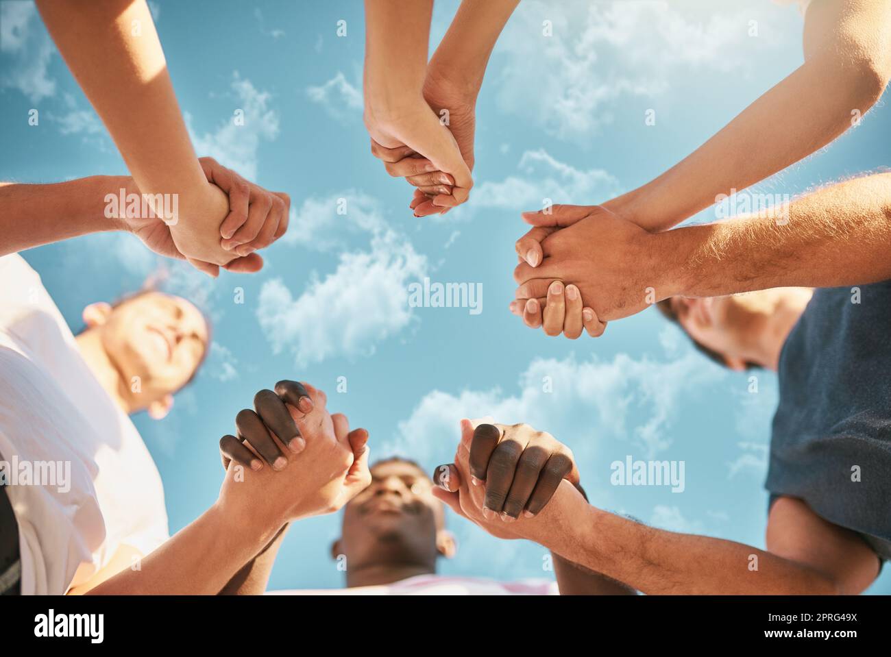 Strengthening friendship bonds. Low angle shot of a group of young friends holding hands. Stock Photo