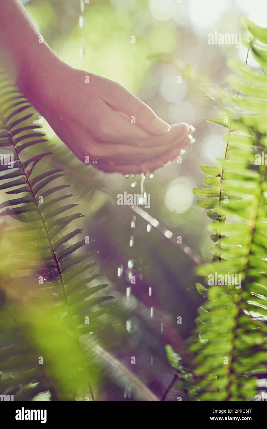 Mother Natures elixir of life. a woman washing her hands outdoors. Stock Photo