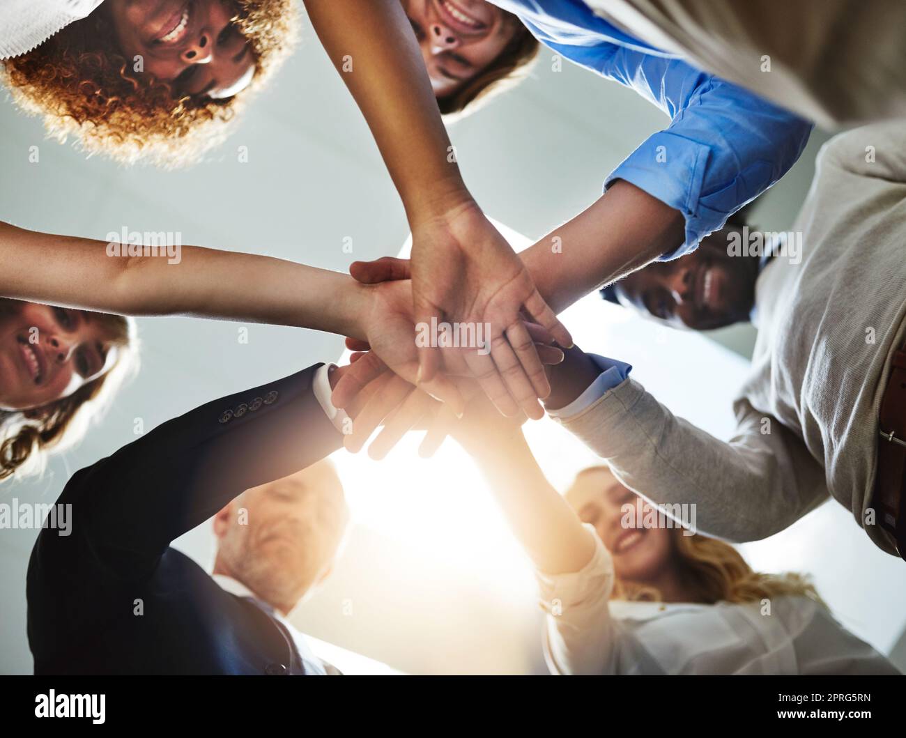 Were so much better together. Low angle shot of a group of colleagues joining their hands in solidarity. Stock Photo