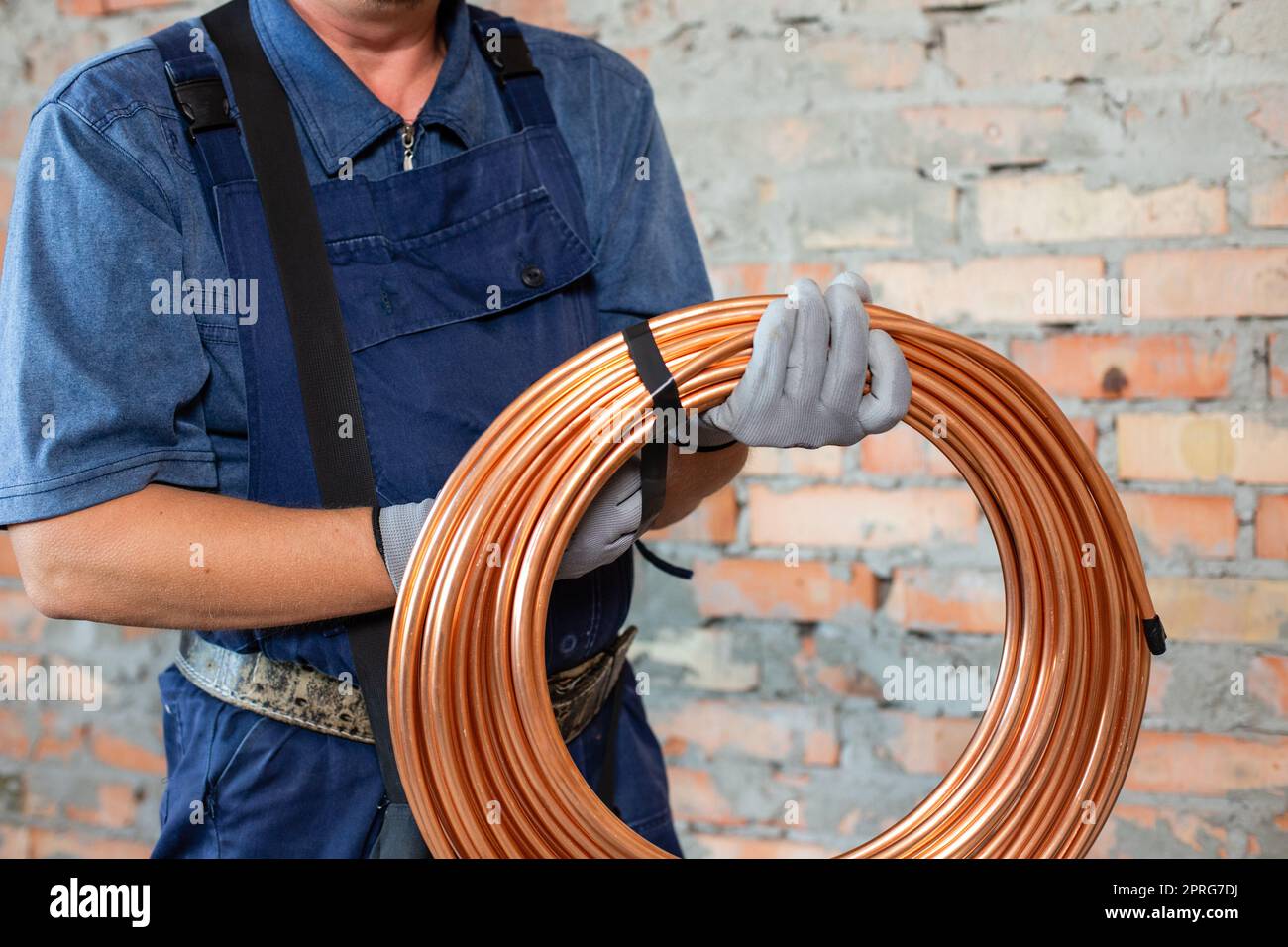 Heating red electrical cable in hands of male electrician technician