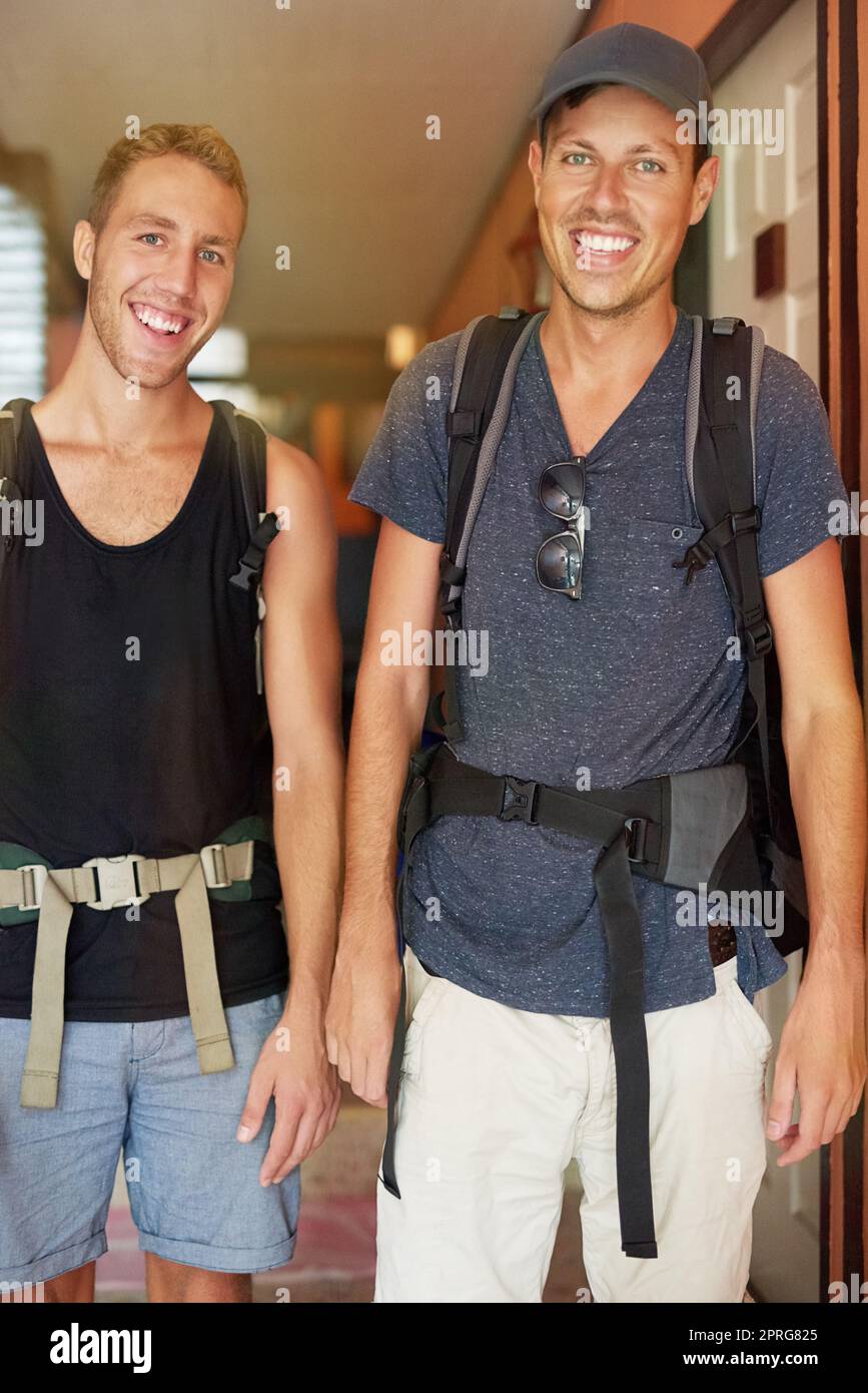 Ready for the road. Portrait of two smiling young friends wearing backpacks traveling together in Thailand. Stock Photo