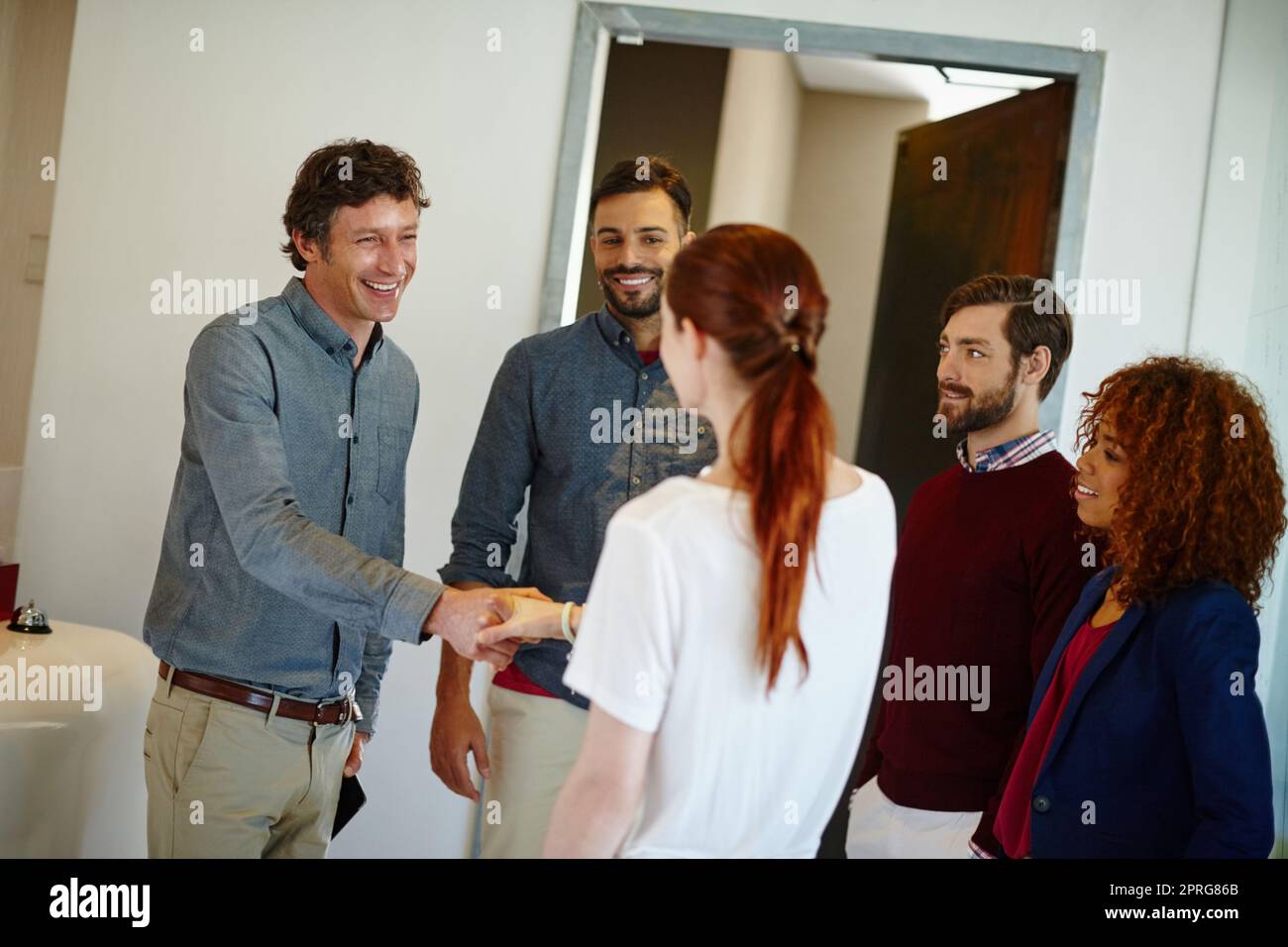 We cant wait to hear your ideas. a young businesswoman being introduced to her new coworkers in the office. Stock Photo
