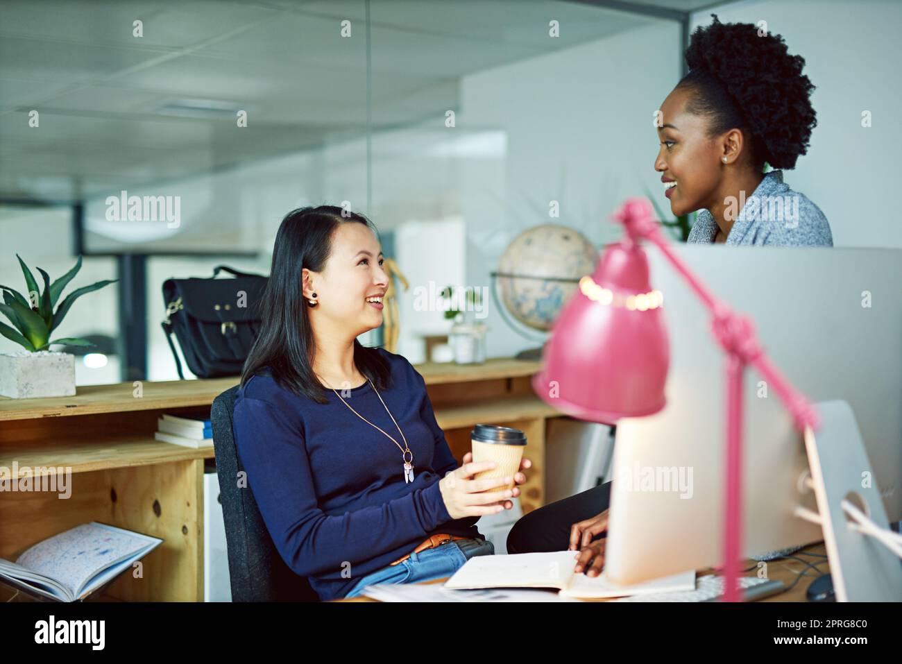 Bringing her an idea. two young businesswomen talking in the office. Stock Photo