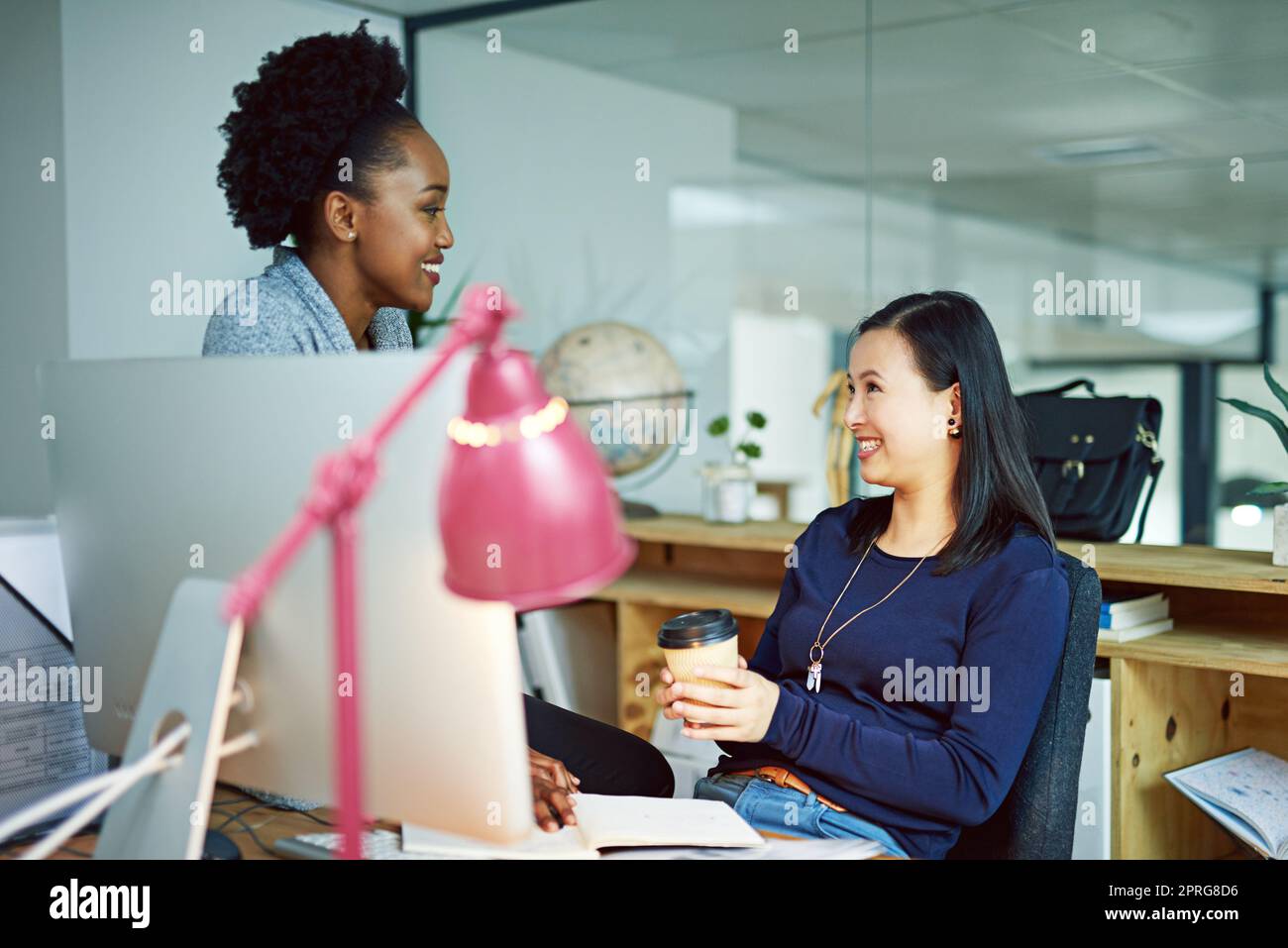 Talking strategy. two young businesswomen talking in the office. Stock Photo