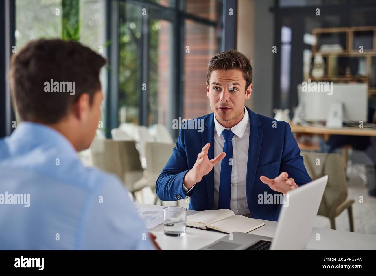 We need to move more swiftly towards our goals. two businessmen having a meeting in an office. Stock Photo