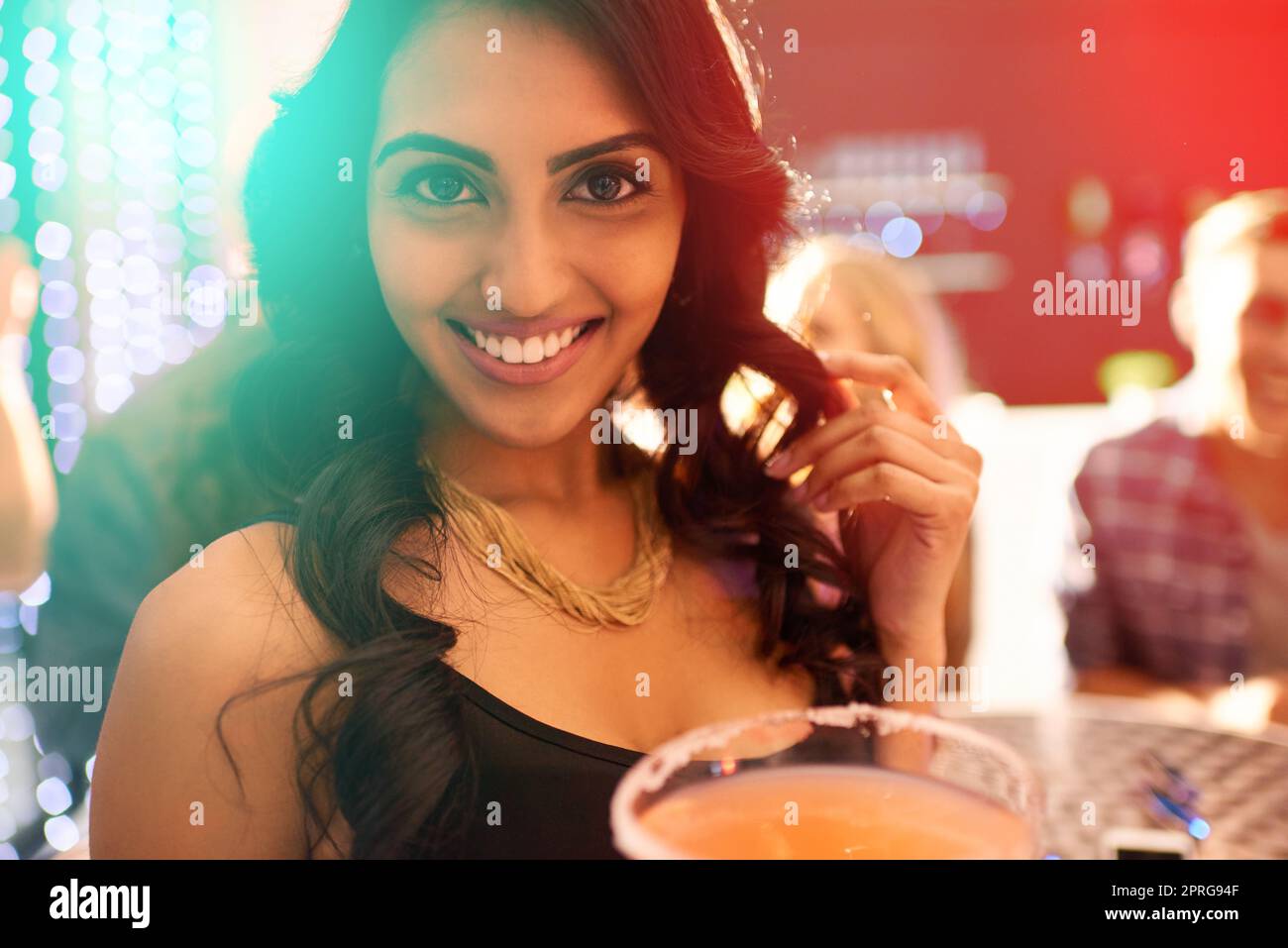 Tonight, we celebrate. Portrait of a young woman drinking a cocktail at a party. Stock Photo