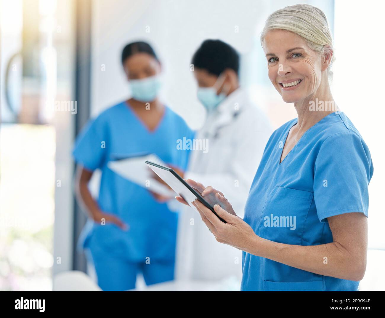 Doctor, smile and medical healthcare professional on tablet for patient records working in hospital building. Trust, consultation and medicine nurse worker with team of health experts Stock Photo