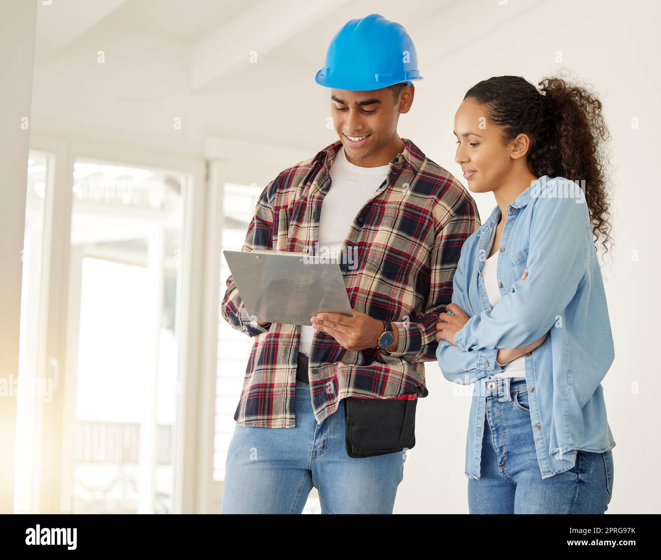 Couple planning home renovation job together, construction worker