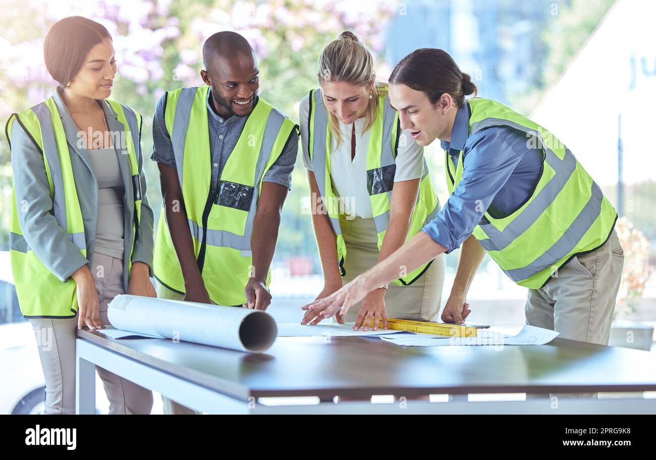 Industrial engineer team planning with blueprint paperwork in a meeting in an office or boardroom. Architect group of people collaborate on a building project working together on the design Stock Photo