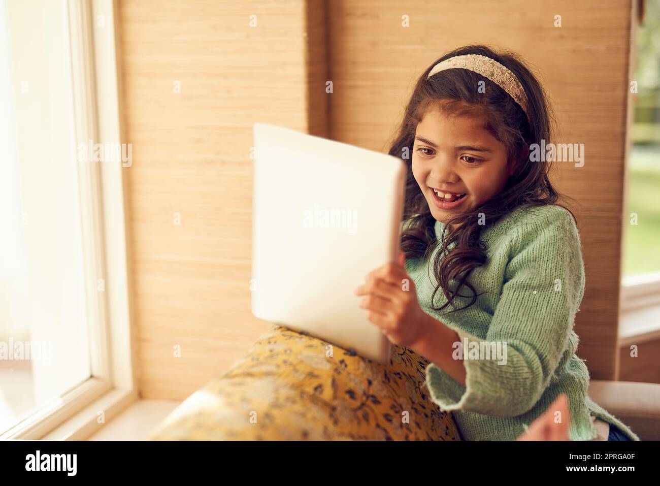 An afternoon with her favourite apps. a little girl using a digital tablet at home. Stock Photo