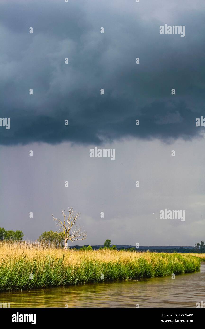 Heavy rain storm clouds wind waves water Oste river Germany. Stock Photo