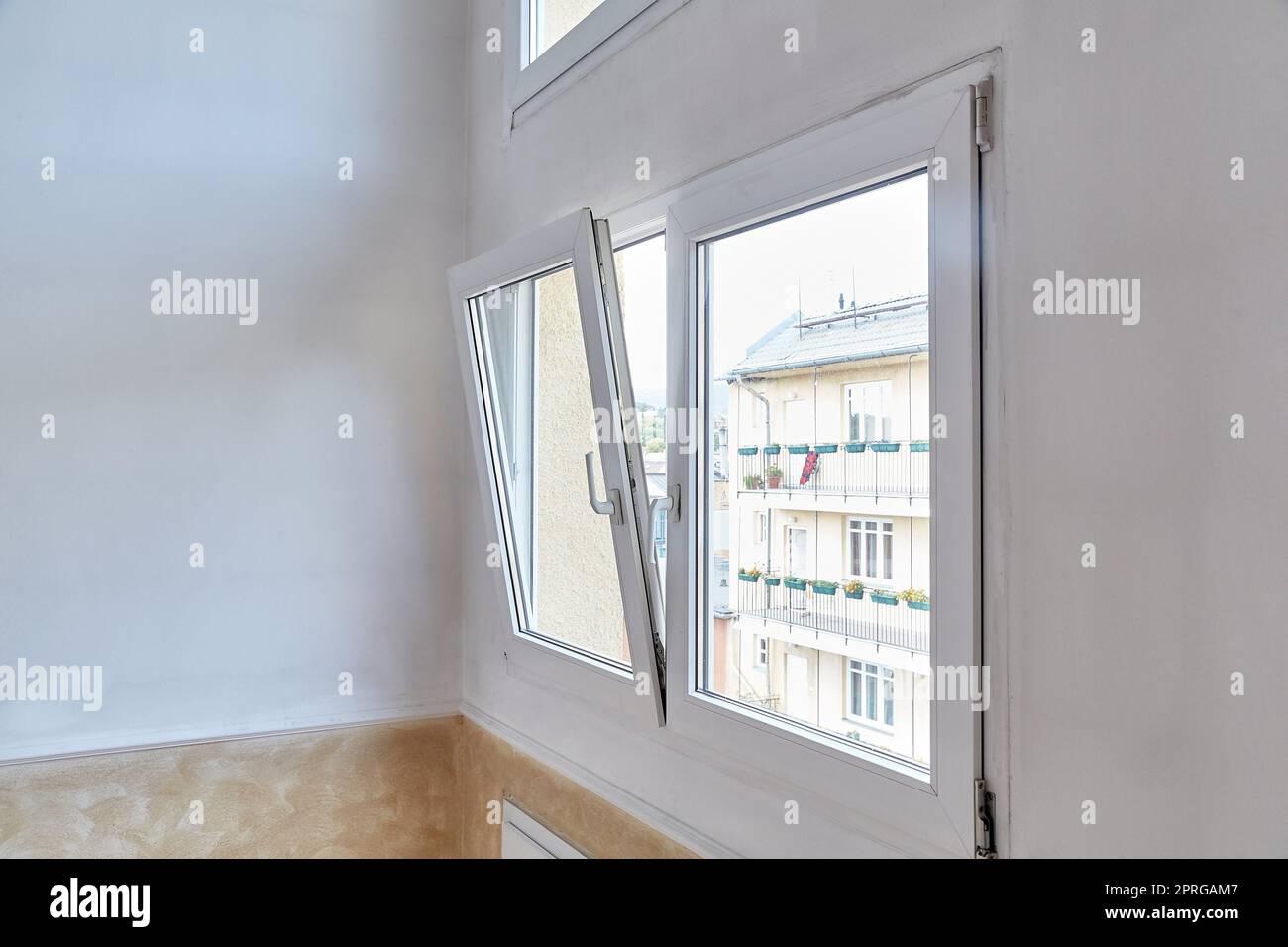 Window tilt open in a city apartment, letting in fresh air Stock Photo